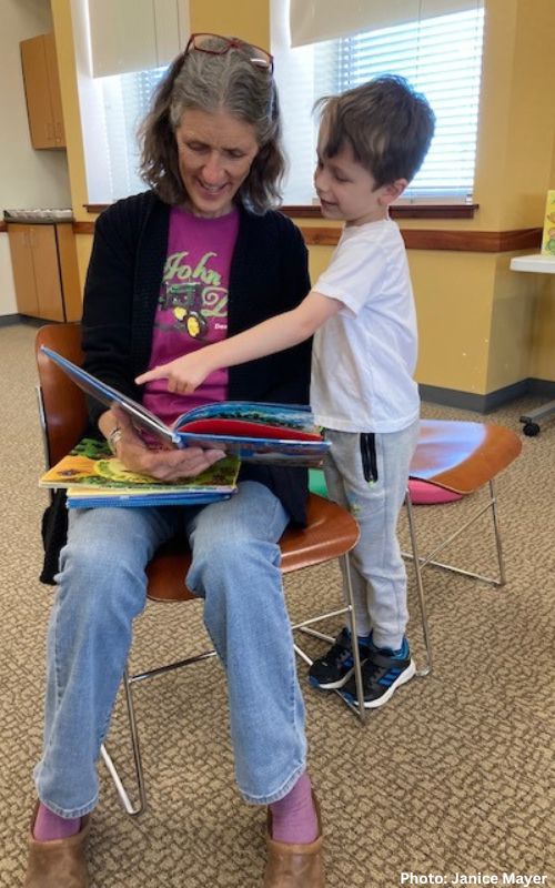Mary Dixon of Green Tractor Farm Reads to Children at the Santa Fe Public Library's Southside Branch with the Assistance of her grandson Major, who was visiting from New York City. Photo: Janice Mayer